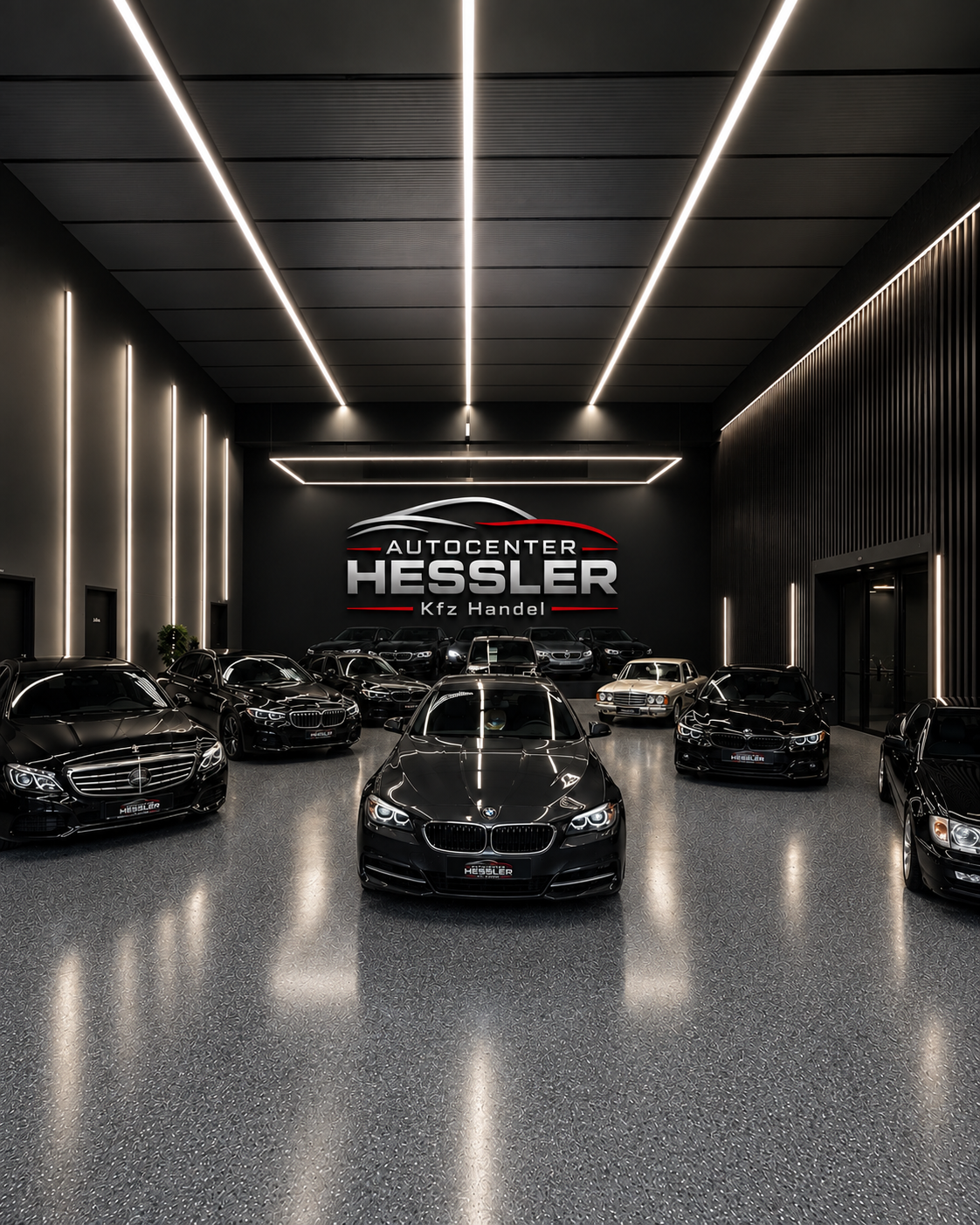 Ausstellungshalle von Autocenter Hessler mit Fahrzeugen und beleuchtetem Logo